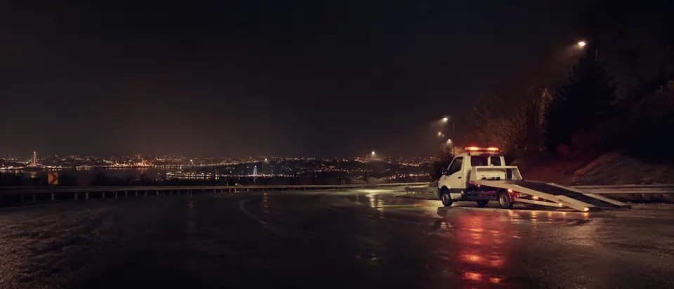 Gece boş bir İstanbul çevre yolunda uyarı lambaları yanan oto kurtarma çekicisi