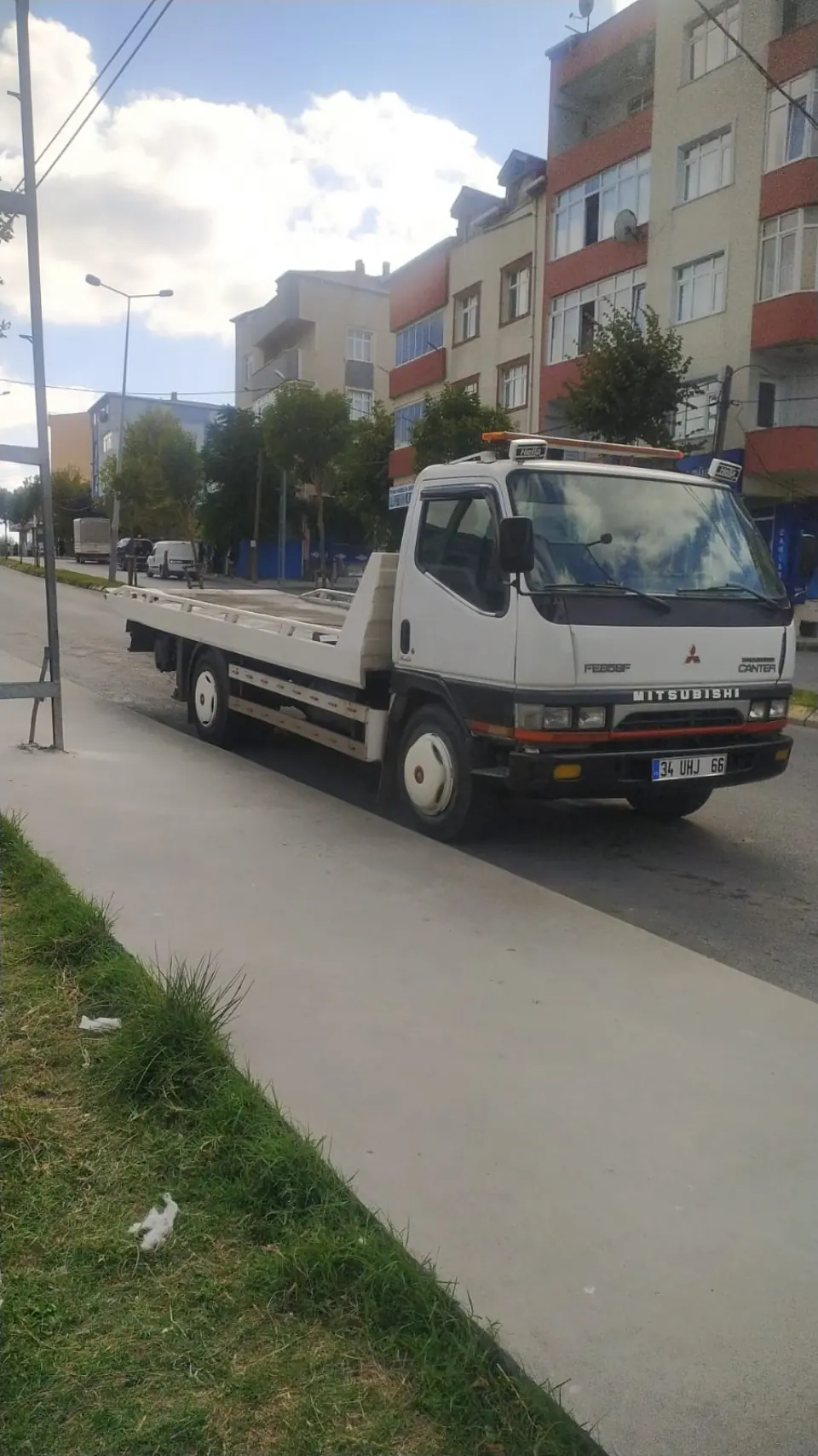 Çetin Oto Kurtarıcı'nın 34 UHJ 66 plakalı beyaz Mitsubishi Canter kayar kasa çekicisi, Arnavutköy'de cadde üzerinde