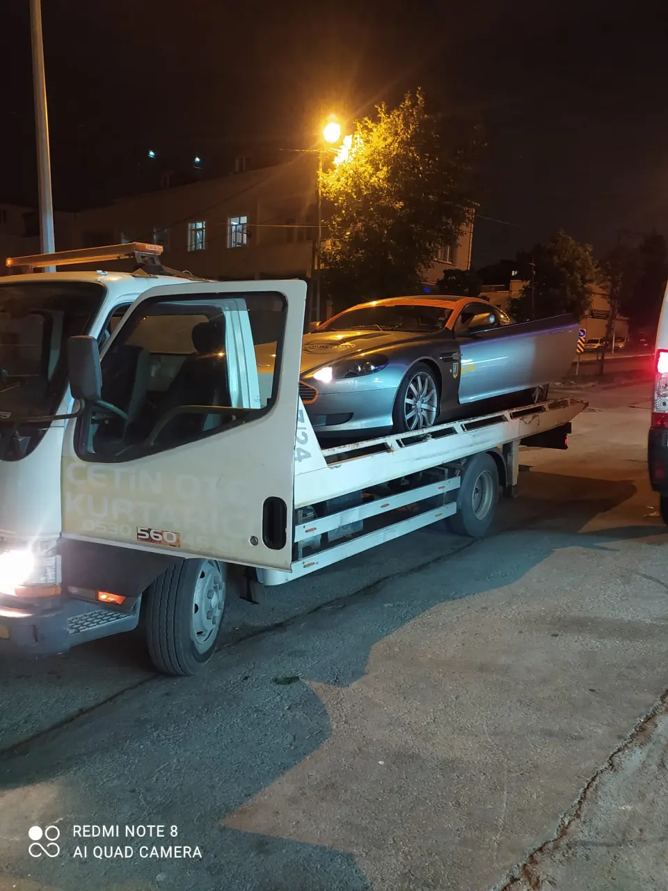 Gece Çetin Oto Kurtarıcı çekicisinin platformunda taşınan gümüş spor otomobil